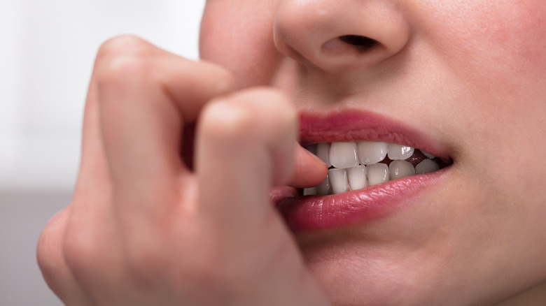 A woman biting her nails