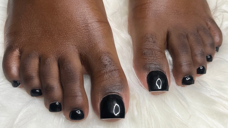 A woman's feet with a long, black pedicure
