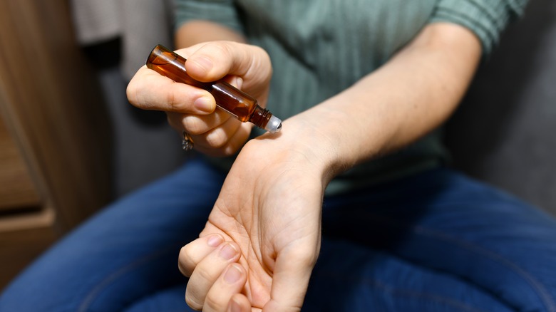 Person applying perfume oil 