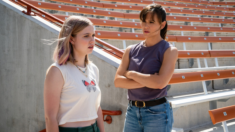 Jennifer Garner looking at a younger blonde actress in front of bleachers