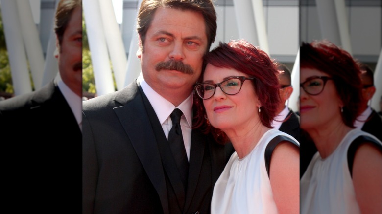 Megan Mullally wearing a white dress with black detailing and Nick Offerman in a black suit and tie