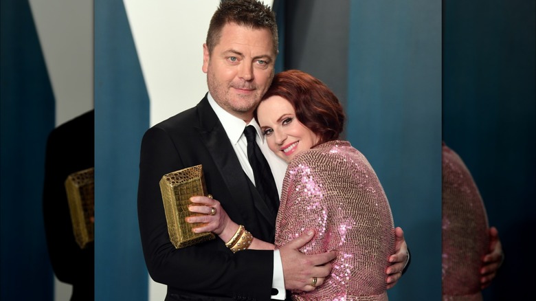 Megan Mullally wearing a pink sequin dress and Nick Offerman in a black suit and tie