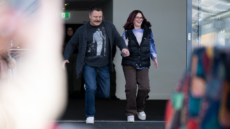 Megan Mullally wearing a blue puffer jacket and Nick Offerman in a grey sweater