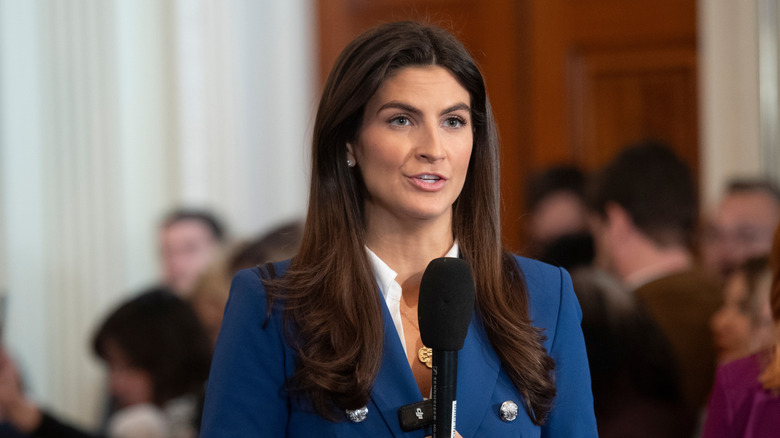 Kaitlan Collins holds a microphone wearing a blue blazer