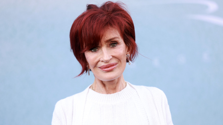 Sharon Osbourne smiles wearing white top
