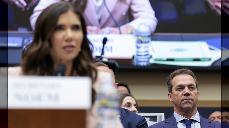 Bryon Noem sitting behind Kristi Noem, whose face is out of focus