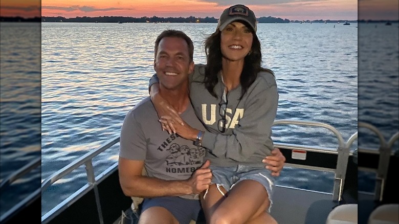 Kristi Noem sitting on Bryon Noem's lap on a boat