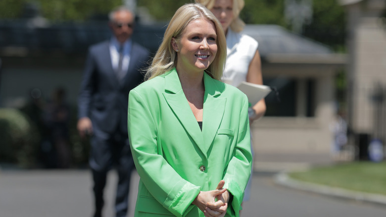 Karoline Leavitt smiling in a lime green blazer