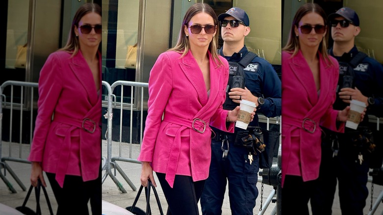 Margo Martin in a pink blazer walking around outside while holding a cup of coffee