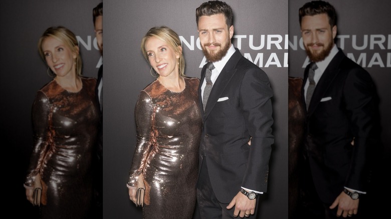 Sam Taylor-Johnson stands in a silver dress next to Aaron Taylor-Johnson frowns