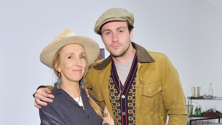 Sam Taylor-Johnson smiles in a hat next to Aaron Taylor-Johnson wearing a hat