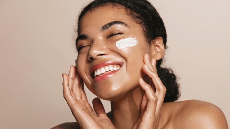 Woman with skincare product on