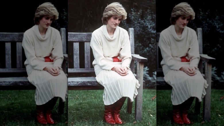 Princess Diana sitting on a bench while wearing cream-colored separates and red accessories