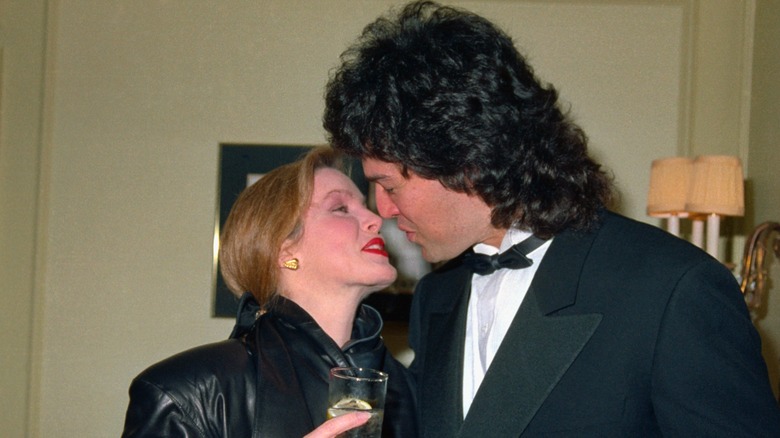 Priscilla Presley about to kiss Marco Garibaldi Garci in 1987 while holding a drink and wearing red lipstick
