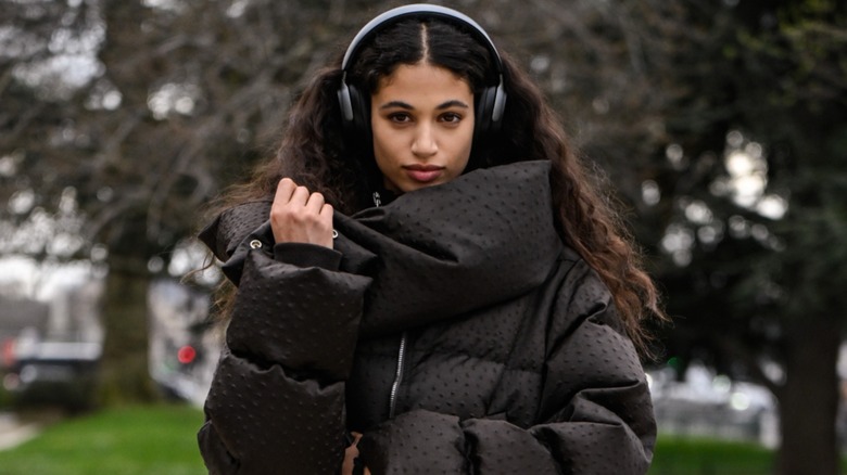 A woman in an oversized black puffer coat