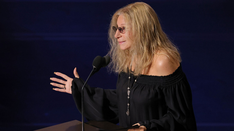 Barbra Streisand gesturing at a podium onstage at the 2026 Academy Awards