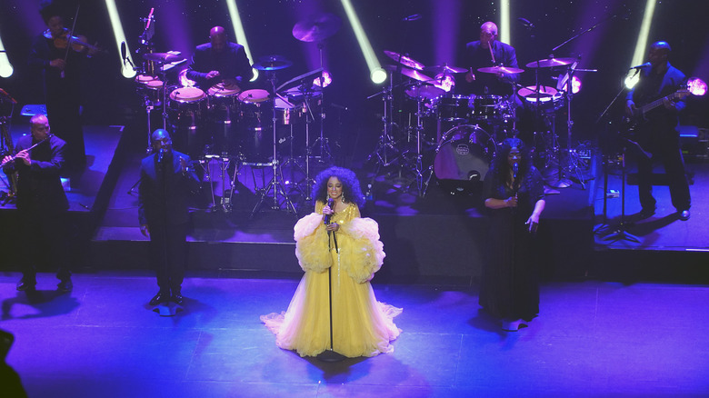 Diana Ross wearing a voluminous yellow dress on stage