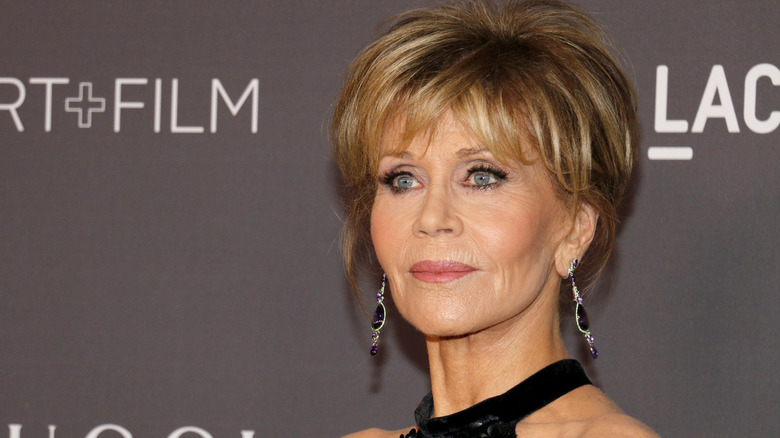 Jane Fonda in a black halter top gown with short hair
