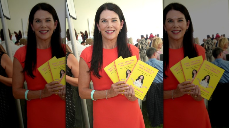 Lauren Graham holding up three copies of her book "Have I Told You This Already?" at the East Hampton Library's Author's Night 2023