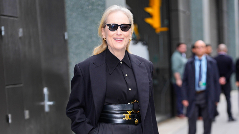Meryl Streep wearing all black and sunglasses on a city street
