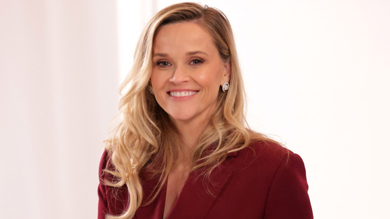 Reese Witherspoon smiling in a red blazer