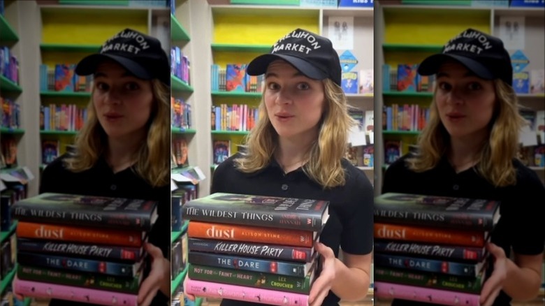 Raegan Revord holding a stack of books