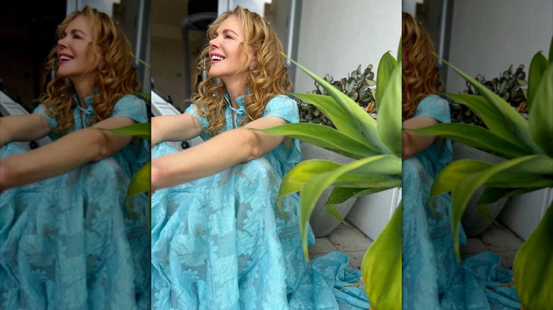 Nicole Kidman laughing while sitting next to a plant
