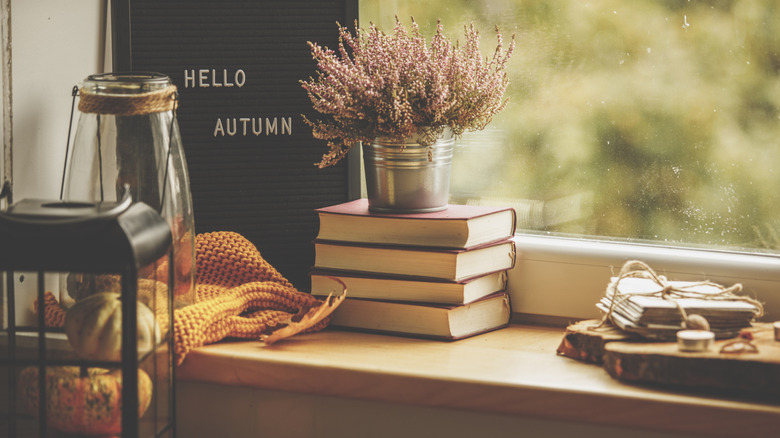 Cozy books stacked next to a sign reading "hello autumn"