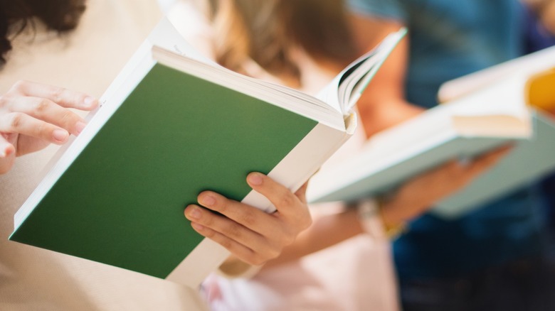 A close-up shot of several women reading books