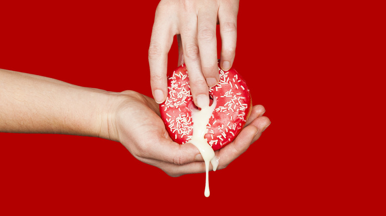 Hands touching suggestive donut
