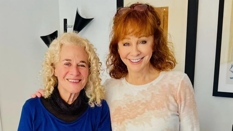 Carole King smiling with Reba McEntire