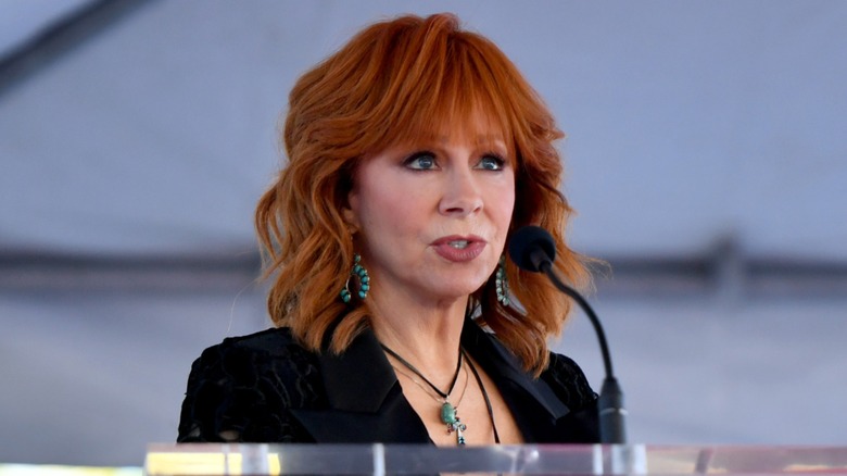 Reba McEntire speaking on stage in 2025