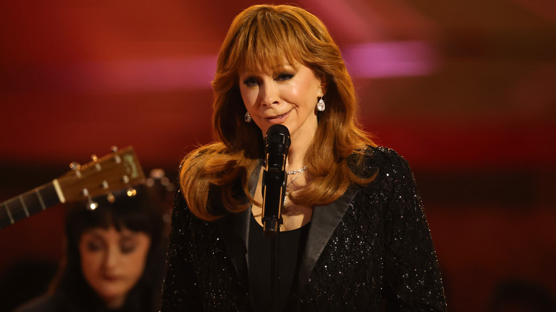 Reba McEntire performing on stage in a sparkly black blazer at the 2026 Grammy Awards