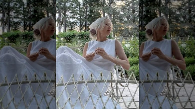 Pamela Anderson sitting on a deck