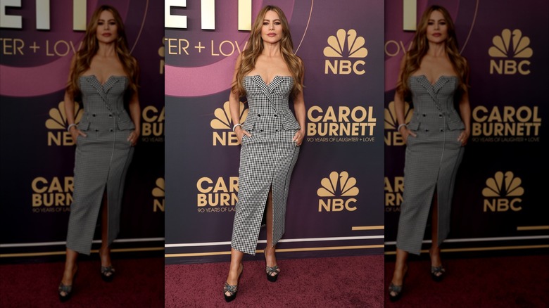 Sofía Vergara posing at an NBC event in a blazer-inspired dress with a strapless neckline and slitted skirt