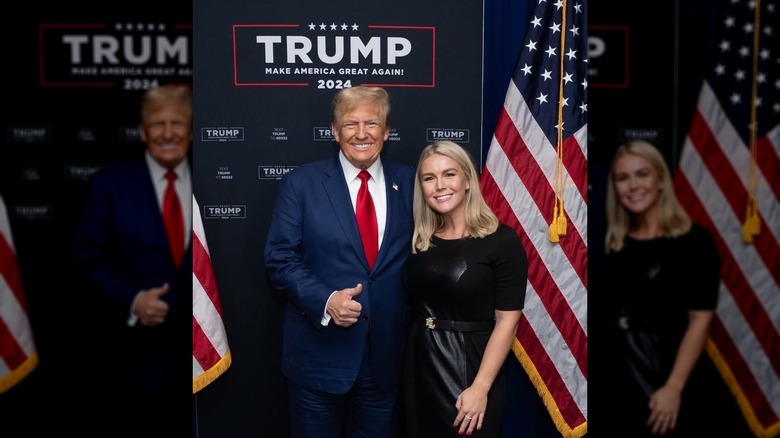 A photo of Karoline Leavitt standing with Donald Trump in front of two American flags and a Trump "Make America Great Again 2024" sign