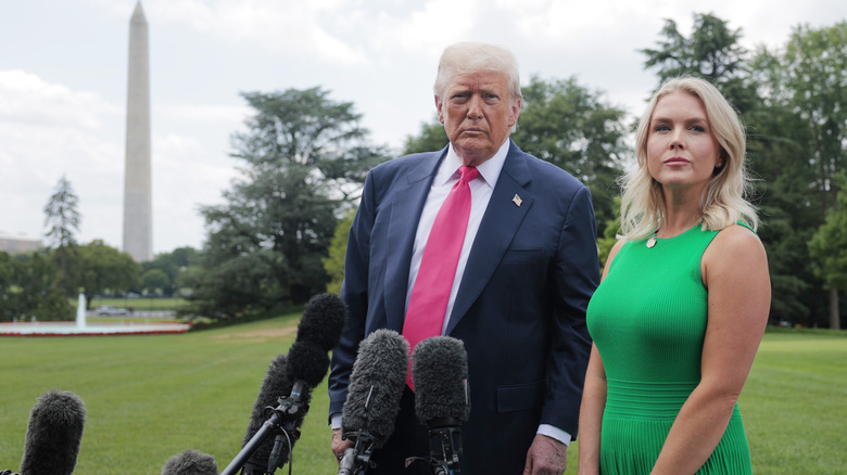 Donald Trump and Karoline Leavitt standing on the White House lawn