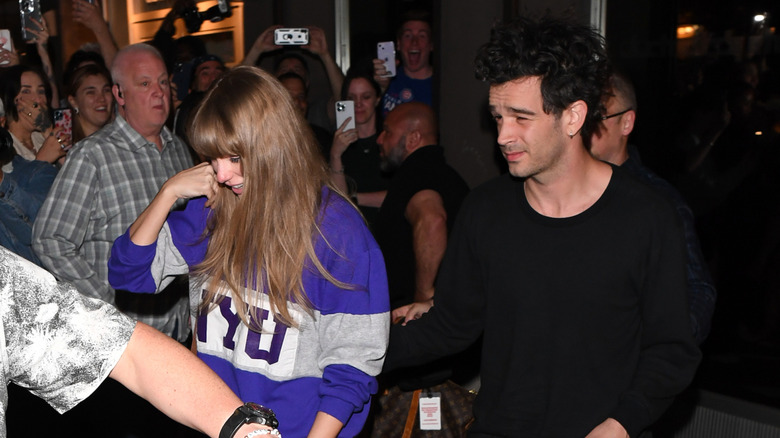 Taylor Swift walking next to Matty Healy