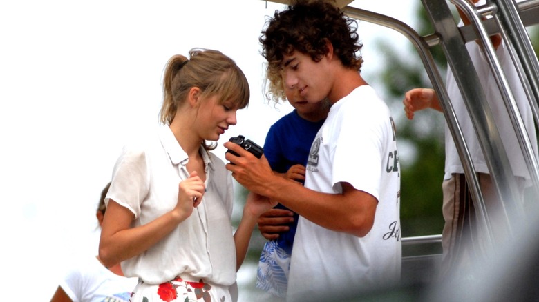 Taylor Swift and Conor Kennedy looking at a camera