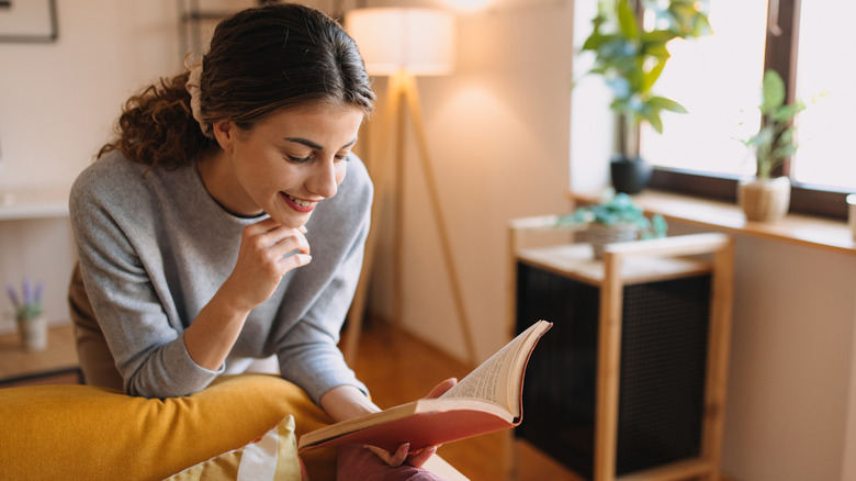 Woman reads a book in the living room