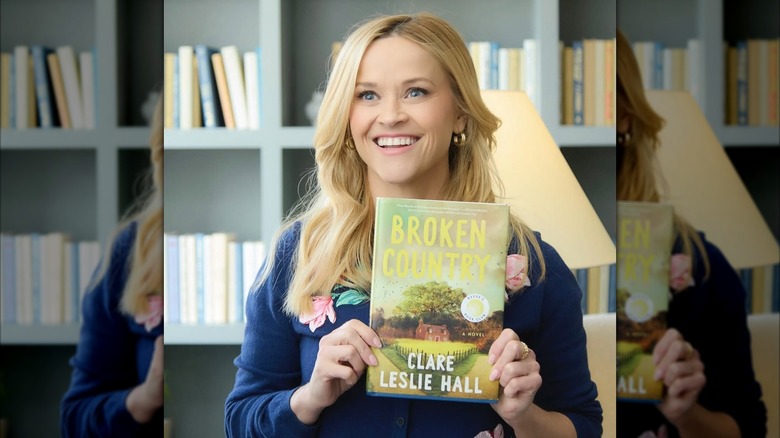 Reese Witherspoon holding a copy of Broken Country by Clare Leslie Hall