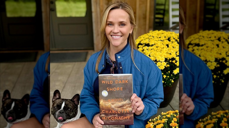 Reese Witherspoon holding Wild Dark Shore by Charlotte McConaghy