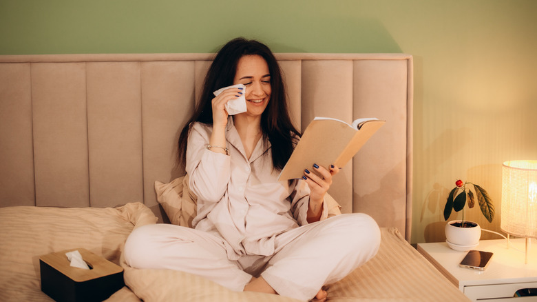 Woman crying while reading a book