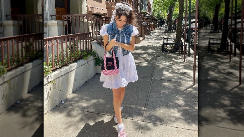 woman on city sidewalk in white sundress
