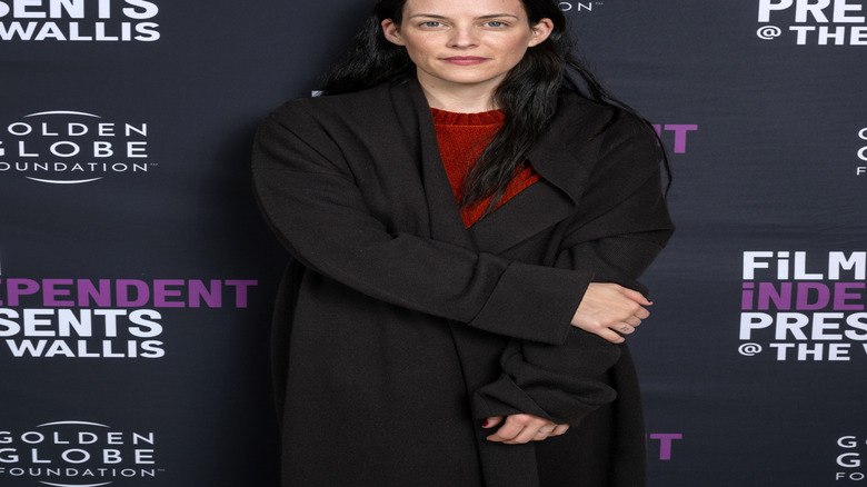 Riley Keough posing with a small smile at a film festival event