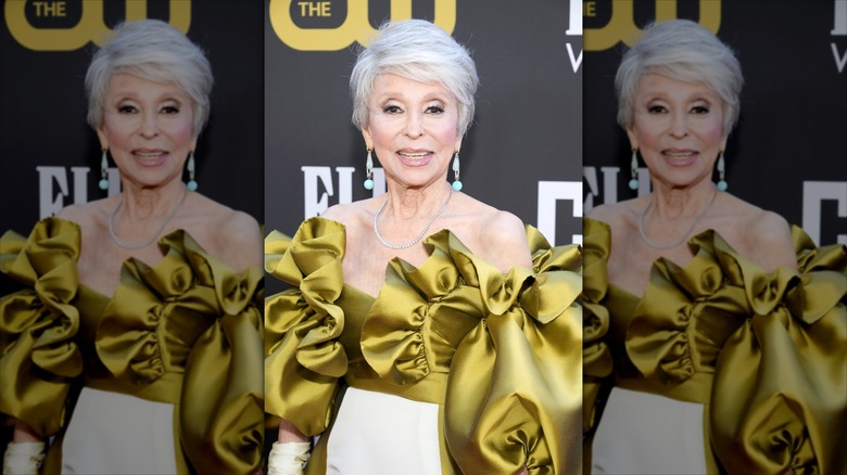 Rita Moreno smiles wearing a ruffled green top