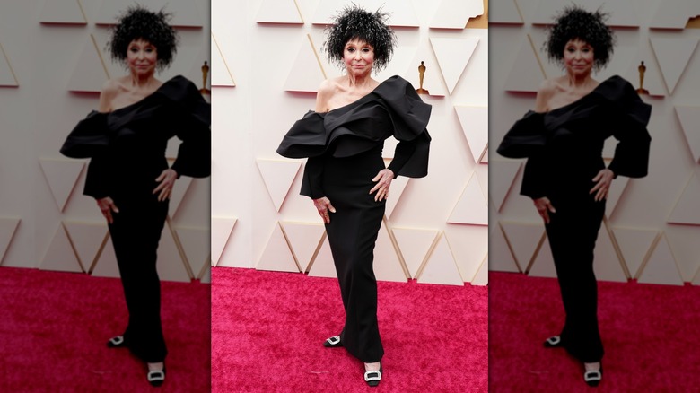 Rita Moreno on the red carpet in a black dress with a feathered hat