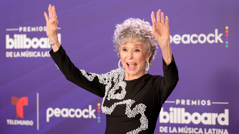 Rita Moreno on the red carpet and waving with both hands