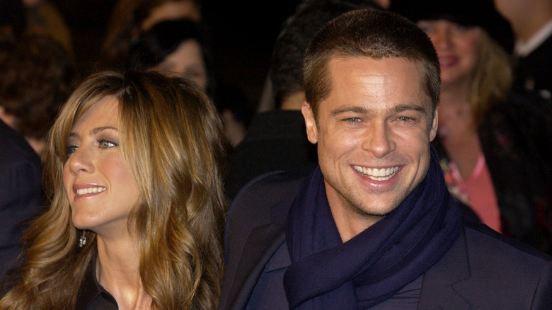 Jennifer Aniston standing next to Brad, both smiling