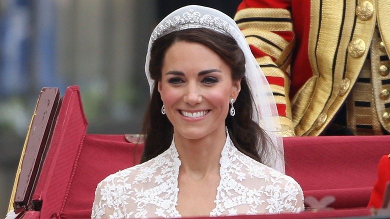 Kate Middleton riding in a carriage and wearing a tiara on her wedding day